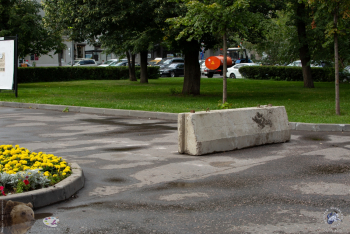 Кинотеатр `Правда` в Москве. Железнобетонный блок закрывающи проезд на парковку с Люсиновской улицы рядом с цветочной клумбой. Фото 03.08.2019.