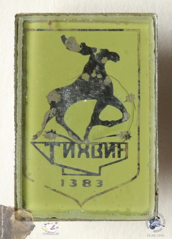 Значок `Тихвин. 1383`. Лось, высекающий копытами икры из наковальни.