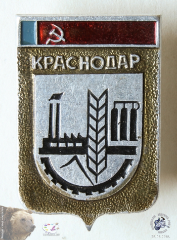 Значок `Краснодар`. Герб-щит с промышленными символами города и серпом с молотом